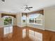 Spacious living room with hardwood floors, a ceiling fan, a chandelier, and sliding doors to the balcony at 7021 Della Dr # 51, Orlando, FL 32819