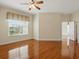 Bright main bedroom featuring hardwood floors, a ceiling fan, a large window, and an ensuite bathroom at 7021 Della Dr # 51, Orlando, FL 32819
