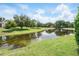 Scenic view of community pond reflecting the sky, surrounded by lush green grass and mature trees at 7021 Della Dr # 51, Orlando, FL 32819