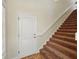 Carpeted staircase with white railing and a door nearby at 7021 Della Dr # 51, Orlando, FL 32819
