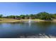 Scenic community lake featuring a water fountain, trees, and clear skies on a sunny day at 711 Swan Ln, Altamonte Springs, FL 32701