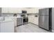 Bright kitchen boasts white cabinets, stainless steel appliances, and modern gray flooring at 711 Swan Ln, Altamonte Springs, FL 32701
