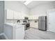 Well-lit kitchen with white cabinets, stainless steel appliances, and vaulted ceiling at 711 Swan Ln, Altamonte Springs, FL 32701