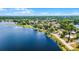 A scenic aerial view of the lakefront neighborhood with lush greenery and homes along the shoreline at 730 S Main Ave, Groveland, FL 34736