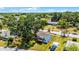 Aerial view of the charming home with wooden deck and large backyard shaded by mature trees at 730 S Main Ave, Groveland, FL 34736