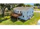 Aerial view of a light blue house with a wooden deck overlooking the backyard at 730 S Main Ave, Groveland, FL 34736