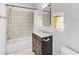 Updated bathroom with marble-look shower, modern vanity, and decorative mirror at 730 S Main Ave, Groveland, FL 34736