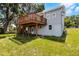A view of the back of the two-story home with a wooden deck overlooking the backyard at 730 S Main Ave, Groveland, FL 34736