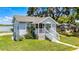Charming exterior view of a light blue home with a welcoming front porch and manicured lawn at 730 S Main Ave, Groveland, FL 34736