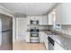 Bright kitchen features stainless steel appliances, granite countertops, and ample white cabinets at 730 S Main Ave, Groveland, FL 34736