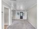 Bright living room featuring neutral walls, carpet floors, and a decorative front door at 730 S Main Ave, Groveland, FL 34736