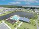 Expansive aerial view of lakefront community featuring a swimming pool, clubhouse, playground, and surrounding homes at 744 Yukon Ln, Debary, FL 32713