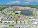 Aerial view featuring a community amenity center, lake, and a neighborhood featuring modern homes with garages at 744 Yukon Ln, Debary, FL 32713