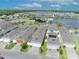 Aerial view of modern homes with garages, showcasing well-manicured lawns, and a community amenity center by the lake at 744 Yukon Ln, Debary, FL 32713
