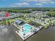 Stunning aerial view of a community pool, playground, and clubhouse overlooking a serene lake, with lush greenery nearby at 744 Yukon Ln, Debary, FL 32713
