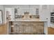 Modern kitchen features a large island with seating, white cabinets, and stainless steel appliances at 744 Yukon Ln, Debary, FL 32713