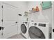 Efficient laundry room with modern appliances, decorative tile floor, and ample shelving for organization at 744 Yukon Ln, Debary, FL 32713