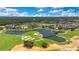 Panoramic aerial view showcases the community's homes, a golf course, and picturesque lakes in a lush landscape at 7905 Jacks Club Dr, Kissimmee, FL 34747