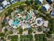 Aerial view of a community swimming pool area with multiple pools, lounge chairs, palm trees, and shaded cabanas at 7905 Jacks Club Dr, Kissimmee, FL 34747