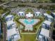 Aerial view of modern apartment complex featuring a geometric pool, landscaped grounds, and ample parking at 7905 Jacks Club Dr, Kissimmee, FL 34747