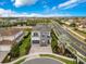 Expansive aerial view of a home with a well-manicured lawn, stone driveway, and neighborhood at 7905 Jacks Club Dr, Kissimmee, FL 34747