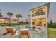 An exterior shot of the backyard features a pool, spa, and patio with a built-in fire pit under a darkening sky at 7905 Jacks Club Dr, Kissimmee, FL 34747
