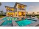 A backyard at sunset features a pool, spa, lounge chairs and an outdoor kitchen and seating area at 7905 Jacks Club Dr, Kissimmee, FL 34747