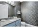 Chic bathroom with patterned wallpaper, a modern vanity, and sleek fixtures, offering a stylish retreat at 7905 Jacks Club Dr, Kissimmee, FL 34747