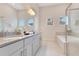 Bright bathroom with double vanity, soaking tub, decorative mirrors, and modern fixtures for a spa-like experience at 7905 Jacks Club Dr, Kissimmee, FL 34747