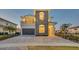 Beautiful two-story home featuring stone accents, manicured landscaping, and a spacious driveway at 7905 Jacks Club Dr, Kissimmee, FL 34747