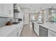 Bright kitchen featuring white cabinetry, stainless steel appliances, an island with sink, and dining area views at 7905 Jacks Club Dr, Kissimmee, FL 34747