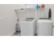 Bright laundry room featuring a washer, dryer, cleaning supplies, and storage shelf for an organized home at 7905 Jacks Club Dr, Kissimmee, FL 34747