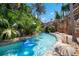 Picturesque lazy river with tropical foliage, rock formations, and a gentle waterfall feature at 7905 Jacks Club Dr, Kissimmee, FL 34747