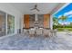 Outdoor dining area featuring a long table, seating for ten, and a fully equipped outdoor summer kitchen at 7905 Jacks Club Dr, Kissimmee, FL 34747