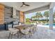 An outdoor kitchen with modern appliances, wooden accents and an elegant dining table with seating for ten overlooks the pool at 7905 Jacks Club Dr, Kissimmee, FL 34747