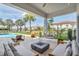 Picturesque outdoor living space featuring a modern hanging chair, a poolside fire pit, and stylish lounge seating at 7905 Jacks Club Dr, Kissimmee, FL 34747