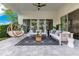 Cozy outdoor living space featuring comfortable sofas, a hanging chair, and a patterned rug for relaxation at 7905 Jacks Club Dr, Kissimmee, FL 34747