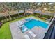 Aerial view of a luxurious pool featuring a spa, fire pit and many areas for sunbathing in this beautiful yard at 7905 Jacks Club Dr, Kissimmee, FL 34747