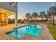 A clear blue swimming pool with a tanning ledge reflects the sunset sky with palm trees and comfortable poolside seating at 7905 Jacks Club Dr, Kissimmee, FL 34747
