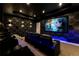 Home theater with tiered seating, a large screen, theater seating, and stylish lighting and wallpaper at 7905 Jacks Club Dr, Kissimmee, FL 34747