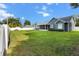 Spacious backyard featuring a large grassy area and a newly built home with modern design at 8717 Se 156Th St, Summerfield, FL 34491