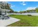 Large backyard with concrete patio, picnic table, green grass, and a white vinyl fence at 8717 Se 156Th St, Summerfield, FL 34491