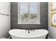 Bathroom featuring a soaking tub in front of a large window providing lots of natural light at 8717 Se 156Th St, Summerfield, FL 34491