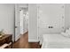 Hallway leading from bedroom with hardwood floors, white doors, and ample lighting at 8717 Se 156Th St, Summerfield, FL 34491