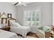 Cozy bedroom with twin beds, window with shutters, hardwood floors, and decorative accents at 8717 Se 156Th St, Summerfield, FL 34491