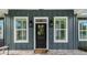 Front door flanked by windows and decorative fixtures at 8717 Se 156Th St, Summerfield, FL 34491