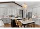 Bright kitchen with white cabinets, marble countertops, island with seating, and a decorative chandelier at 8717 Se 156Th St, Summerfield, FL 34491