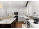 Well-equipped kitchen featuring white cabinets, stainless steel appliances, and a sleek marble countertop island at 8717 Se 156Th St, Summerfield, FL 34491
