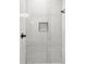 Modern shower features sleek white subway tile, a niche with geometric tile, and updated fixtures at 8717 Se 156Th St, Summerfield, FL 34491