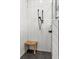 Modern walk-in shower featuring white herringbone tile walls and a wood bench at 8717 Se 156Th St, Summerfield, FL 34491